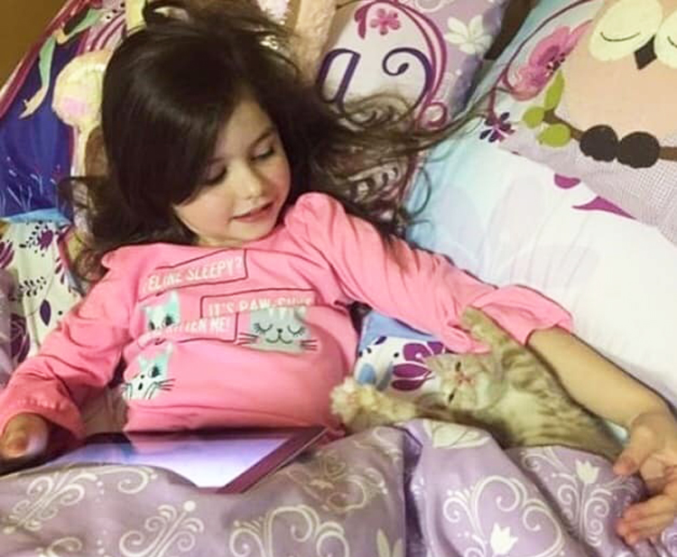 girl with kitten in bed
